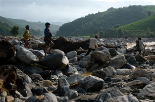 Hai mươi nóc nhà của khu dân cư ven suối Tùng Chỉn, thuộc bản Tùng Chỉn 1 xã Trịnh Tường, huyện Bát Xát (Lào Cai) với 195 nhân khẩu hầu hết là người Dao giờ chỉ còn lại một nóc nhà của gia đình ông Lý Kin Nùng khuất sau hẻm núi là thoát được con lũ khủng khiếp rạng sáng ngày 9/8/2008. Mười chín ngôi nhà còn lại đã biến mất hoàn toàn không để lại dấu tích gì. Chiều 10/8/2008, một ngày sau cơn lũ cuồng điên, chúng tôi đến đây để tìm những gì còn lại của bản Tùng Chỉn 1. Cái gọi là tài sản có thể tìm được của 19 hộ dân ấy, là một chiếc xe máy, một chiếc đầu máy khâu hỏng, một chiếc ăng ten vô tuyến, nửa thớt dưới bằng đá của một cối xay đậu. Các cháu thiếu nhi tìm giúp thêm được một bức ảnh kẹt giữa hai phiến đá. Kết quả của 3 giờ đồng hồ tìm kiếm chỉ có thế. Xẩm tối chúng tôi phát hiện thêm một con chó lủi thủi tìm về nơi có lẽ là nền nhà của chủ nó.
Còn nhiều nữa là nước mắt của người sống khóc cho 19 người chết và mất tích. Còn nhiều nữa là sự hoang mang tột cùng của gần 100 người sống sót sau trận lũ. Vẫn còn nữa là tình người đang dang tay đùm bọc nhau trong hoạn nạn. Trong cơn lũ này, đến với dân rất nhanh là những người lính Biên phòng, ba giờ sau cơn lũ dữ, cán bộ chiến sĩ đồn biên phòng 263 đã có mặt tại bản tìm, đưa những người còn sống đến nơi an toàn... Đang đến và còn tiếp tục đến là tấm lòng yêu thương, xót xa của người dân cả nước.
(Giải Đặc biệt Giải ảnh báo chí Khoảnh Khắc Vàng 01)